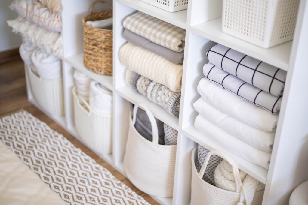 A photo of a neatly organized linen closet, inspiring spring cleaning throughout your closets, with custom storage solutions from The Closet Butler