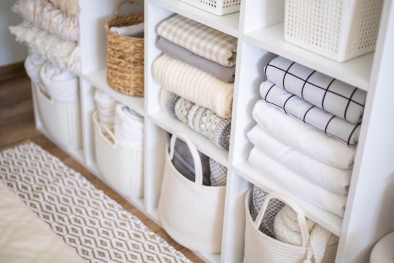 A photo of a neatly organized linen closet, inspiring spring cleaning throughout your closets, with custom storage solutions from The Closet Butler