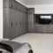 Modern garage with tall dark wood cabinets along the left wall and a silver sports car in the foreground.