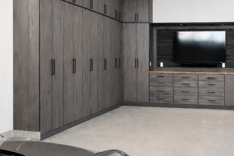 Modern garage with tall dark wood cabinets along the left wall and a silver sports car in the foreground.