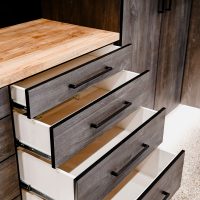 An organized garage highlighting the space, details of custom cabinetry, shelving, and other storage solutions.