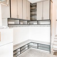 Corner storage mudroom style garage storage with overhead cabinets.