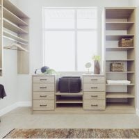 Custom closet featuring warm neutral wood finishes, organized shelves, and stylish hanging spaces for clothing and accessories.