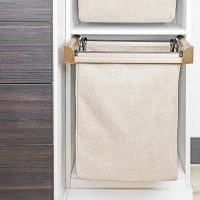 Custom closet design featuring hidden laundry baskets seamlessly integrated into the cabinetry, promoting a clean and tidy appearance while providing functional storage.